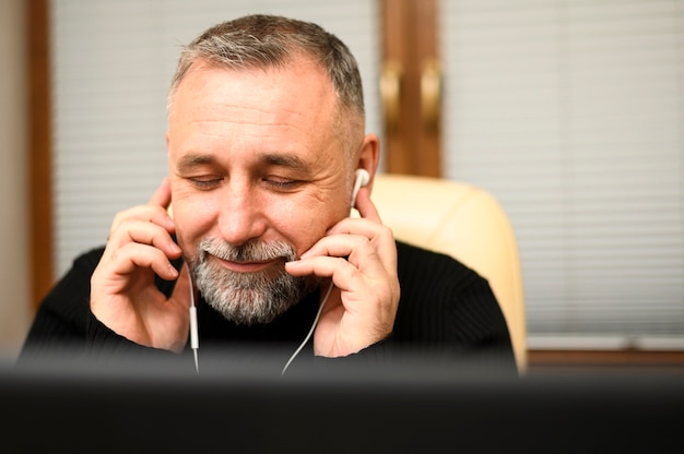 Smiley homme mûr, écouter de la musique