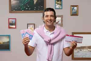 Photo gratuite smiley homme riche tenant des billets de loterie vue de face