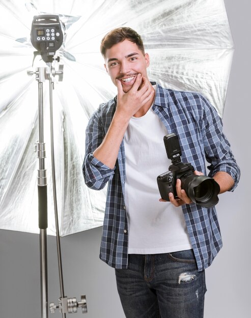 Smiley homme tenant un appareil photo professionnel