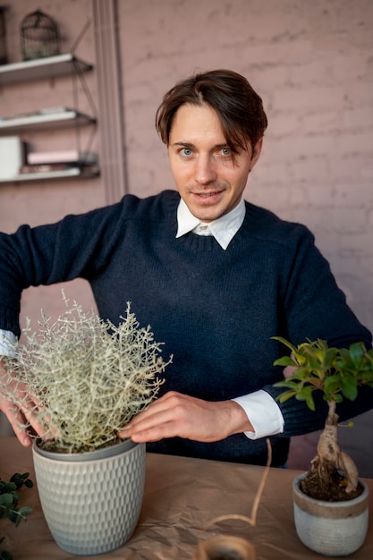 Smiley homme travaillant au magasin de fleurs coup moyen