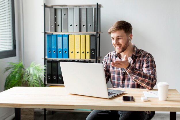 Smiley homme travaillant sur ordinateur portable