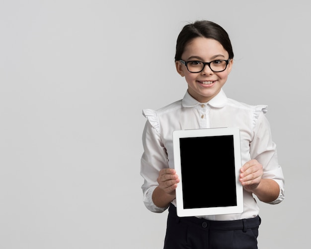 Smiley jeune fille tenant une tablette avec espace copie