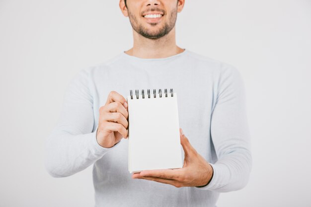 Smiley jeune homme tenant un cahier