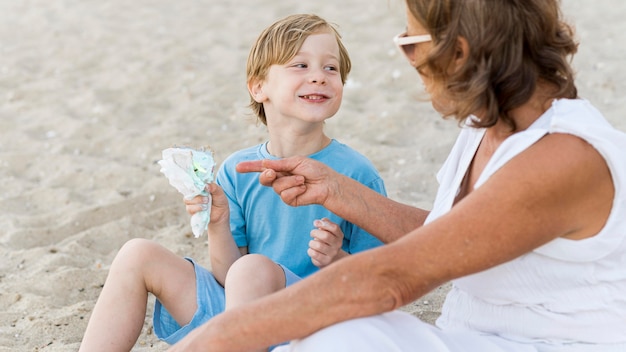 Smiley kid avec grand-mère sur la plage