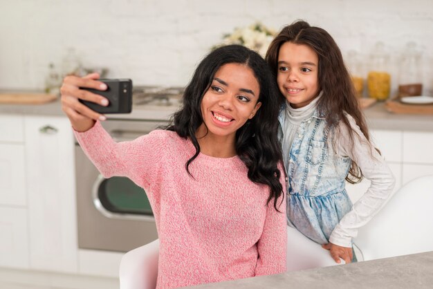 Smiley maman et sa fille prenant des photos