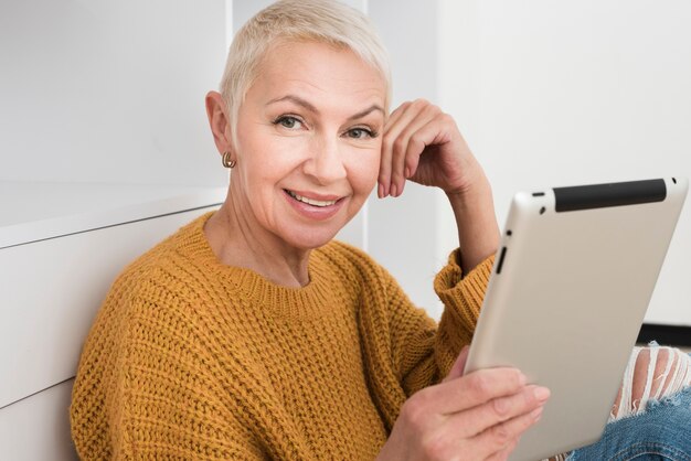 Smiley mature woman holding tablet