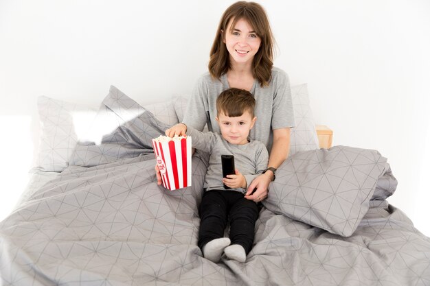 Smiley mère et fils partageant du pop-corn