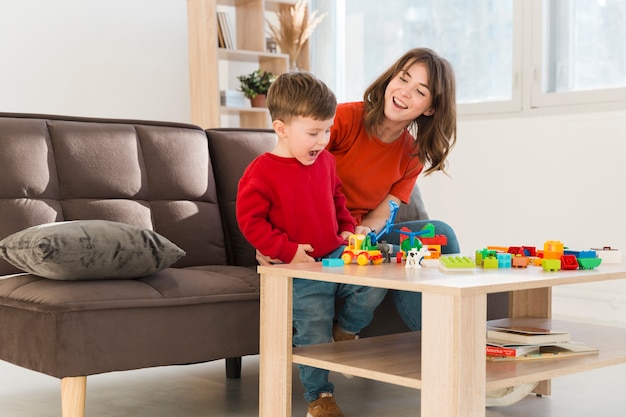 Photo gratuite smiley mère regardant son fils jouer