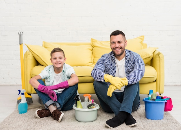 Smiley Père Et Fils Posant à Côté De Produits De Nettoyage