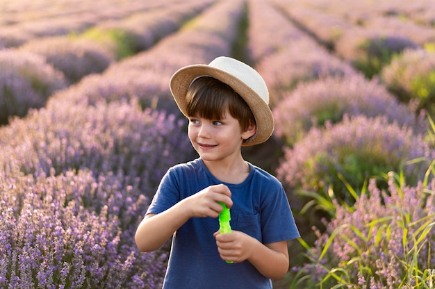 Photo gratuite smiley petit garçon dans un champ de fleurs