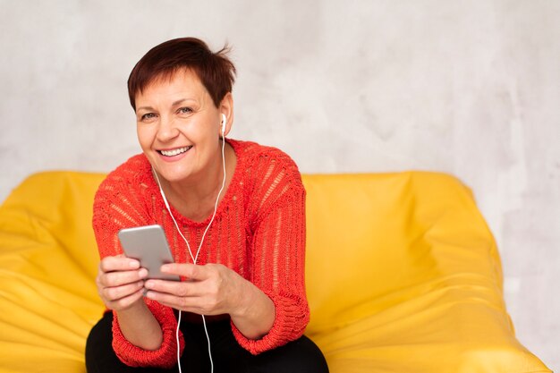 Smiley senior femelle écoute de la musique