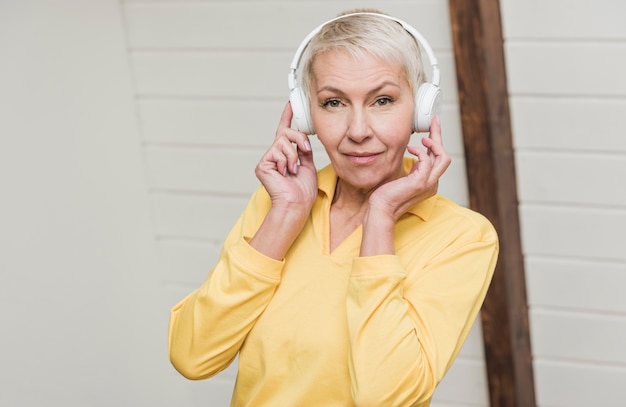 Smiley senior woman écouter de la musique si les écouteurs