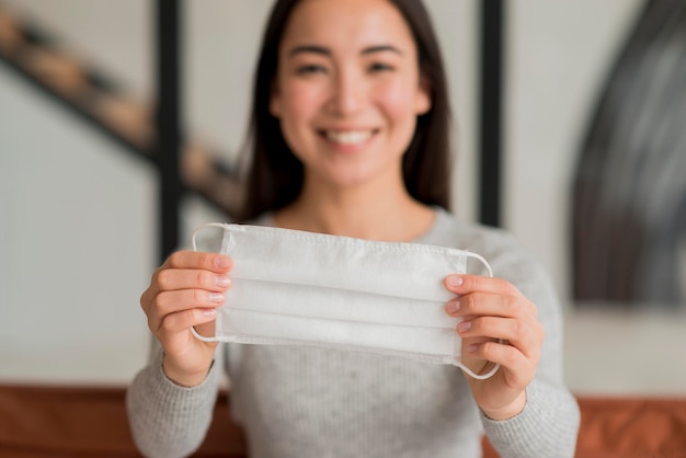 Smiley woman holding mask