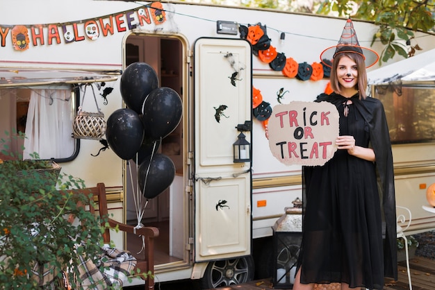 Smiley woman holding truc ou traiter signe