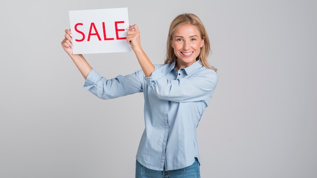 Smiley woman holding up sale sign