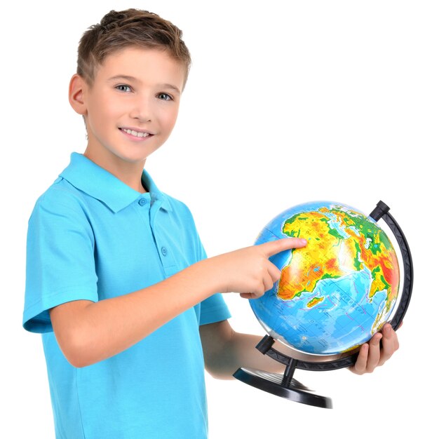 Smiling boy in casual holding globe avec dans les mains et les points dessus - isolé sur blanc