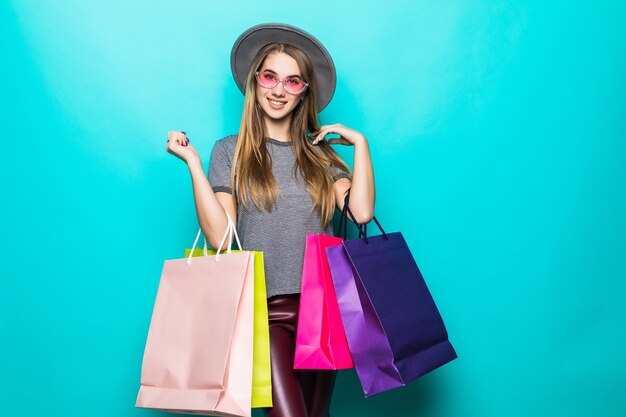 Smiling shopping woman smiling et portant un chapeau isolé sur fond vert