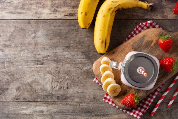 Smoothie fraise et banane fraîche en pot sur table en bois