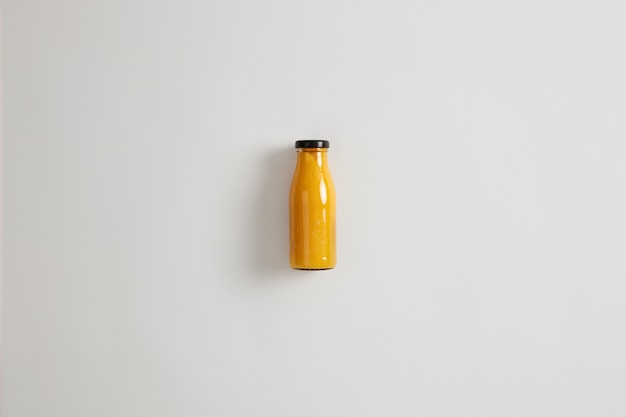 Smoothie orange ananas mangue maison fraîche en bouteille en verre isolé sur fond blanc. Combinaison équilibrée de glucides, de fibres, de protéines et de graisses saines. Boisson qui maintient un déficit calorique