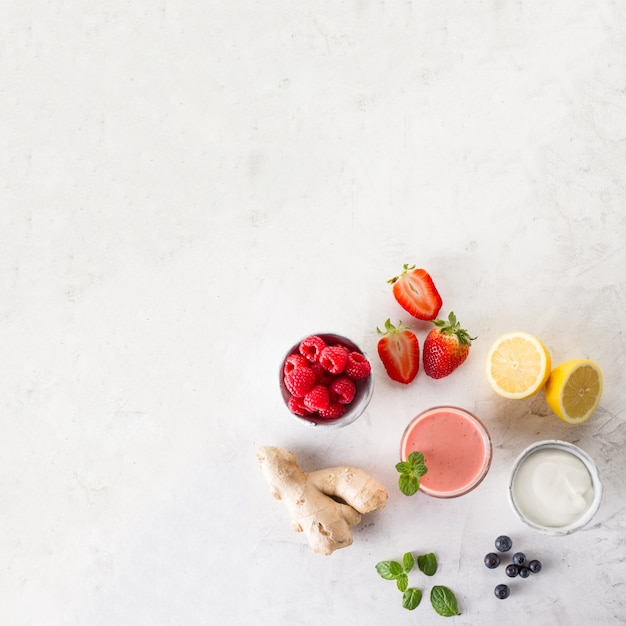 Photo gratuite smoothie rouge frais avec ingrédients vue de dessus