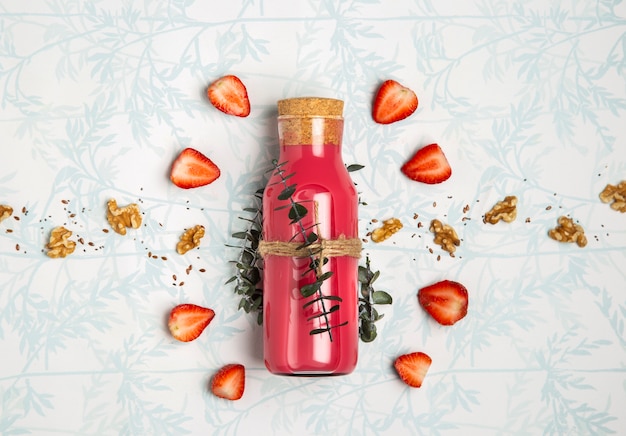 Smoothie rouge avec des graines de noix sur fond mignon