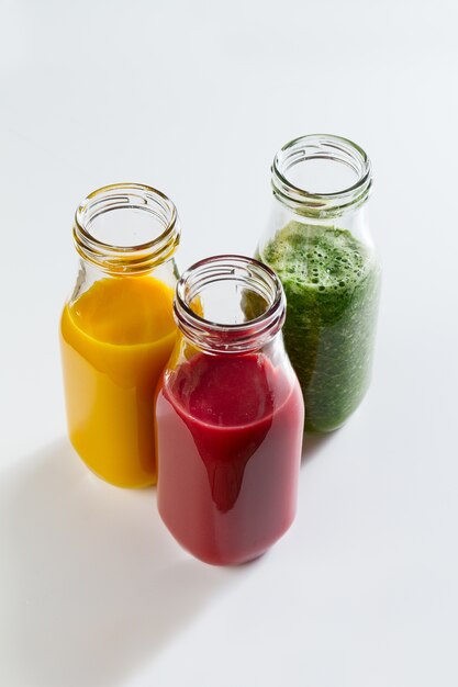 Des smoothies faits maison colorés délicieux et colorés dans des pots en verre sur un fond lumineux. Fermer. Vie saine, concept de désintoxication.