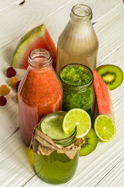 smoothies verts et rouges dans un pot avec citron vert, kiwi