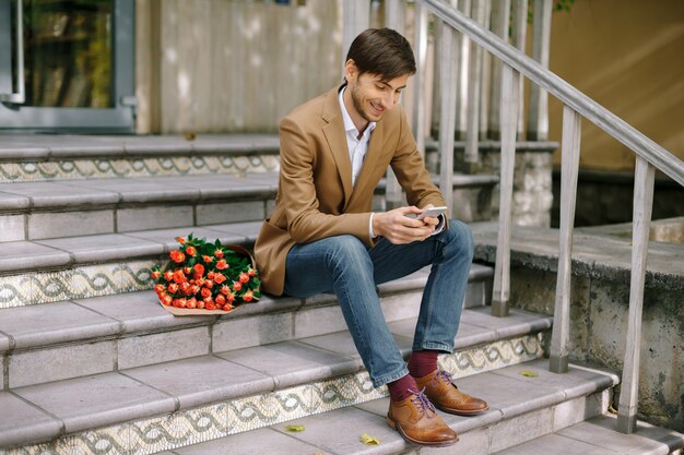 SMS homme souriant tout en regardant le téléphone