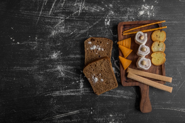 Snack board avec du pain, des frites et des pâtisseries