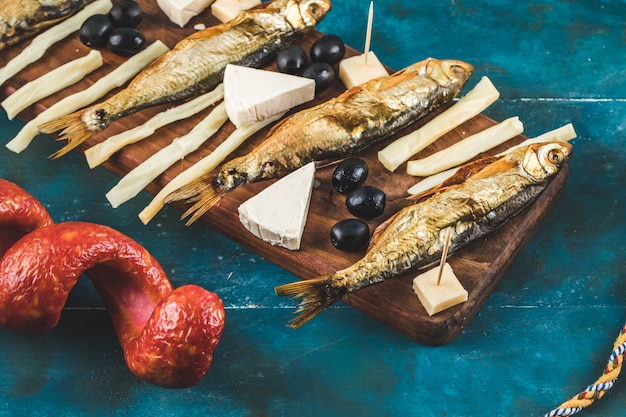 Snack board avec saucisse, fromage, olives et poisson