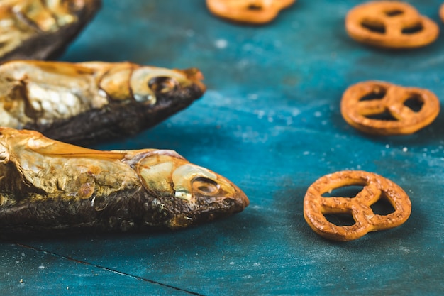 Snacks de poisson séché sur le fond bleu avec des craquelins de bretzel