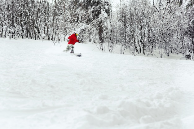 Photo gratuite snoboarder fait un tour de coque descendant sur la neige