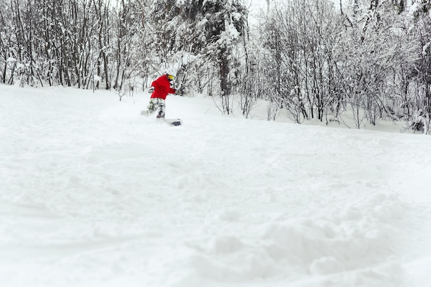 Snoboarder fait un tour de coque descendant sur la neige