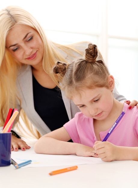 La sœur aînée enseigne à la sœur cadette comment dessiner