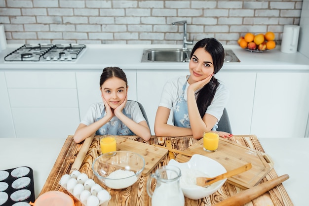 Des soeurs drôles préparent la pâte, feront des biscuits dans la cuisine