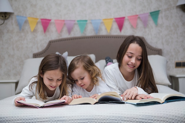 Photo gratuite sœurs en lisant un livre ensemble