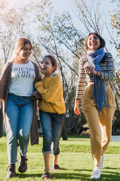 Sœurs souriantes heureux marchant ensemble dans le parc