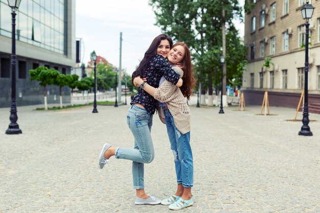 Soeurs souriantes insouciantes étreindre et s'amuser ensemble