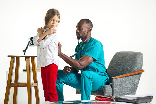 Soins de santé et concept médical - médecin avec stéthoscope à l'écoute de la poitrine de l'enfant à l'hôpital