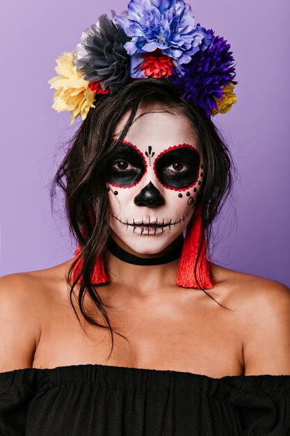 Sorcière confiante contre le mur lilas. Femme mexicaine avec art corporel posant.