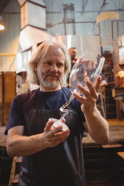 Photo gratuite souffleur de verre examinant la verrerie