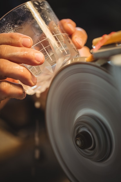 Photo gratuite souffleur de verre polissant et rectifiant une verrerie