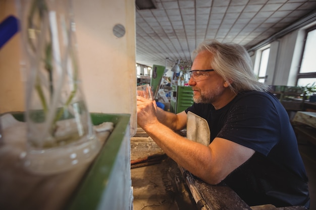 Photo gratuite souffleur de verre polissant et rectifiant une verrerie