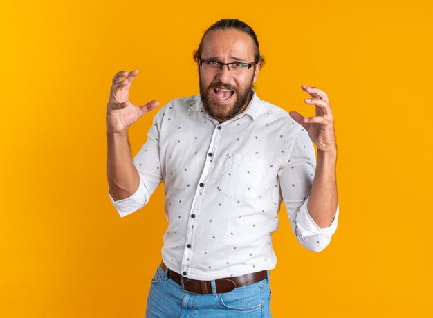 A souligné un bel homme adulte portant des lunettes en gardant les mains en l'air en criant