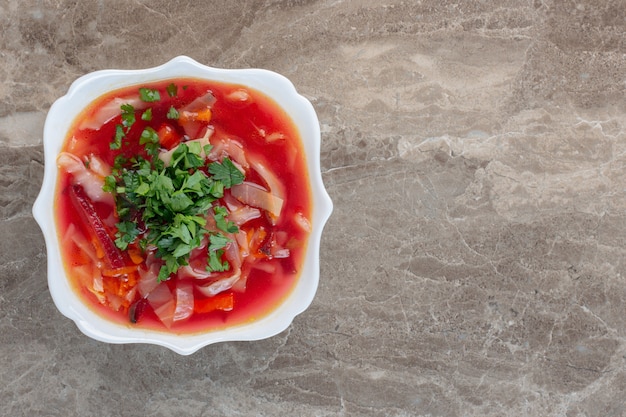 Soupe au bortsch bien chaude avec garniture de coriandre sur marbre.