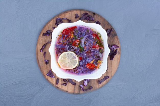 Soupe au chou violet dans un bol blanc sur un plateau en bois