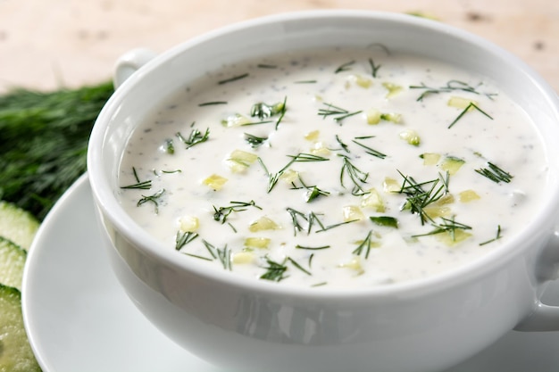 Soupe au lait aigre tarator bulgare dans un bol sur une table en bois.