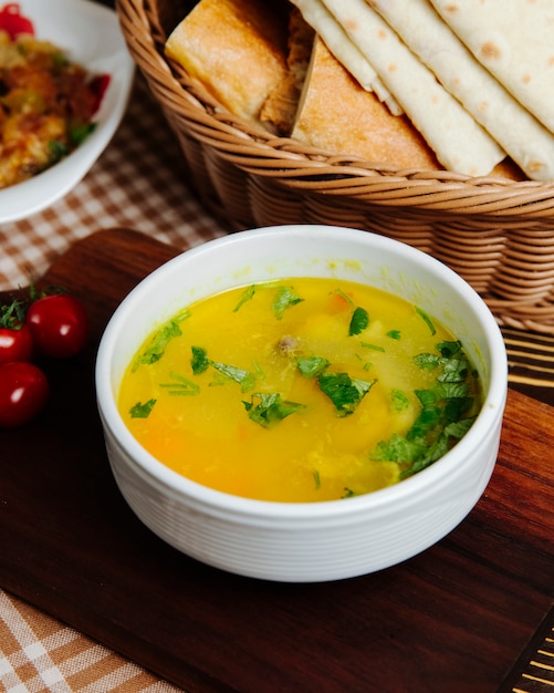 Soupe au poulet, carottes, pommes de terre, verts, vue latérale