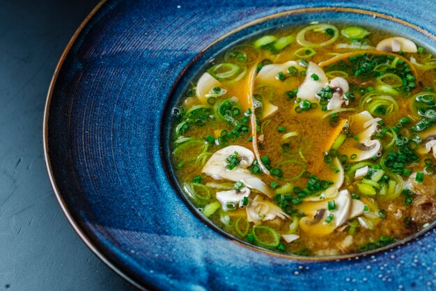 Soupe aux champignons et oignons verts dans une assiette