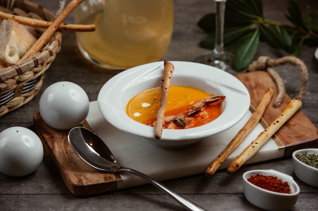 Soupe aux lentilles servie avec des bâtonnets de pain